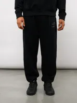 Pantalón jogger negro de felpa sin frisa, con logo Umbro bordado en la pierna izquierda y puños elásticos en los tobillos.
