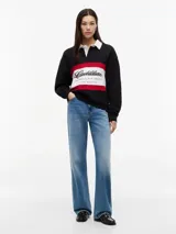 Chomba de rugby de manga larga Tommy Hilfiger en colaboración con Cadillac Formula 1 Team. Presenta un diseño en bloques de color negro, blanco y rojo, con cuello estilo rugby en color blanco y cierre frontal oculto. Incluye el logo de Cadillac en fuente script y el logo de Tommy Hilfiger estampados en el pecho.