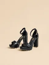 Sandalias de plataforma y taco alto de charol negro, con tira delantera ancha, tira ajustable al tobillo con hebilla dorada y talón cerrado.
