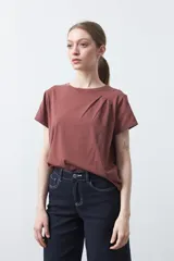 Remera básica de manga corta en color blanco, con cuello redondo y detalle de pliegues sutiles en los hombros.