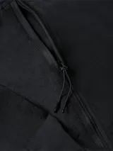 Campera negra con capucha de nailon reciclado, estilo blusón, con cierre de cremallera, bolsillos delanteros con cremallera, puños y dobladillo elásticos, tirador de cremallera con la marca e insignia con el logo de Calvin Klein en la manga.