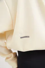 Buzo corto oversize color marfil con elástico en el ruedo inferior y bordado en la espalda.