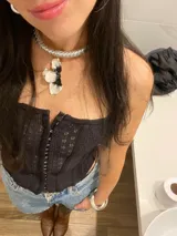 Gargantilla plateada tejida con dije de flor blanca y centro negro.