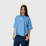 Remera de corte oversize color celeste, con cuello redondo y estampa gráfica pequeña centrada en el pecho.