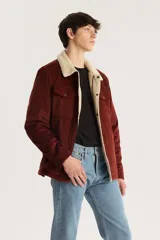 Campera marrón de pana con cuello y forro de sherpa color crema, cierre frontal con cremallera y bolsillos con solapa abotonada en el pecho.