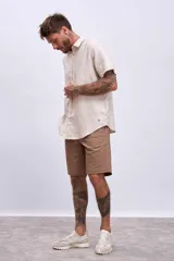 Bermuda de gabardina color marrón claro, corte recto, con bolsillos laterales y traseros.