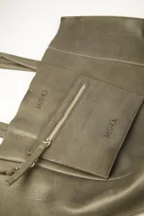 Bolso tipo tote de cuero vacuno en tono gris verdoso, con doble asa de hombro, acabado sin forrar y cierre con broche imán.
