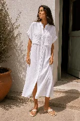 Vestido camisero largo de lino, con cuello mao, mangas cortas con vuelta y bolsillos frontales con solapa. Presenta cierre frontal con botonadura completa.