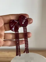 Caravanas de fiesta hechas a mano con base de porcelana irregular color bordó y tiras de strass a tono.