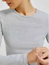 Camiseta de manga larga ajustada al cuerpo, color blanco, con cuello redondo.