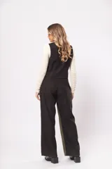Pantalón de tiro alto con bolsillos delanteros y traseros, cierre frontal con cremallera y botón. Diseño a bloques en negro y verde.