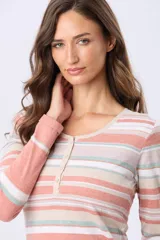 Remera manga larga con cuello redondo y botones, con estampado de rayas horizontales en tonos lavanda, beige, blanco y celeste.