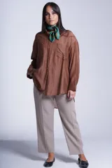 Camisa negra de tela traslúcida con cuello clásico, cierre frontal con botones y dos bolsillos de parche en el pecho.