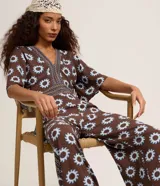 Mono largo de viscosa con estampado gráfico de soles, escote en V profundo, mangas cortas amplias y aberturas laterales en la cintura.