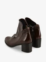 Botín de cuero acharolado negro con taco bloque y punta fina.