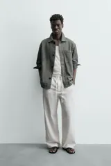 Pantalón de corte regular fit confeccionado en mezcla de algodón y lino. Presenta cintura elástica con cordón ajustable, cierre frontal con cremallera y botón, bolsillos laterales y bolsillo trasero de vivo con botón.