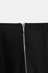 Pantalón de tiro alto en color negro, con diseño de corte recto y ligeramente acampanado. Presenta costuras verticales marcadas en el frente y bolsillos laterales de vivo.