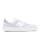 Championes New Balance modelo T500, color lila con la clásica "N" en blanco en los laterales y detalles metalizados en el talón. Combinan gamuza y malla, con una suela de goma blanca.