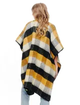 Ruana de tejido soft, marca Barrington, con diseño a cuadros grandes en tonos mostaza, gris oscuro y blanco. Presenta terminación en zig zag con lana en los bordes.