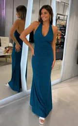 Vestido largo verde con acabado satinado brillante, escote halter cruzado en V y diseño drapeado en el torso.