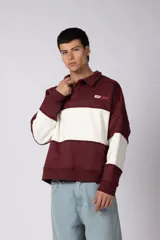 Buzo tipo polo de calce relajado con diseño de bloques de color en tonos marrón y blanco. Presenta cuello polo, cierre frontal parcial y logo estampado en el pecho. Confeccionado en tejido pesado con estructura.