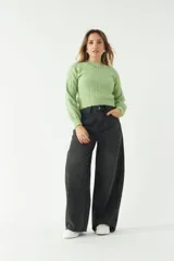 Sweater verde claro tejido con diseño de ochos, corte a la cintura y mangas largas.