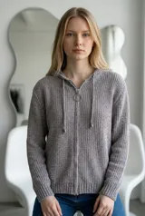 Sweater tipo campera de tejido de punto acanalado en color crudo, con cierre frontal completo, capucha con cordones ajustables y puños y ruedo tejidos en rib.