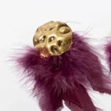 Aros colgantes con base circular dorada y flecos de plumas color mostaza.