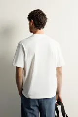 Camiseta de corte relajado confeccionada en tejido de algodón, con cuello redondo acabado en rib y manga corta.