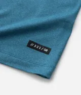 Remera deportiva de hombre con tecnología dry fit, cuello redondo y manga corta. Presenta un diseño liso en color beige con una pequeña etiqueta decorativa en el dobladillo.