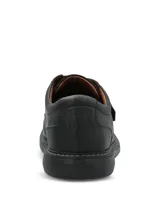 Zapato de cuero negro con textura granulada, diseño de punta redonda, suela de goma EVA y cierre de velcro con tira ancha.