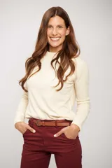 Buzo de tejido liso color crema, de manga larga y cuello redondo.