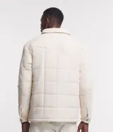 Campera puffer de terciopelo cotele color crema, con cuello inglés, manga larga, abotonado delantero y bolsillos de solapa en el pecho.