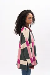 Saco largo de punto con diseño geométrico de cuadros en tonos verde, rosa y crema. Presenta cuello tipo polo, cierre frontal con botones y puños en color bordó.