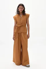 Pantalón palazzo color caramelo, de tiro alto y confeccionado en lino.