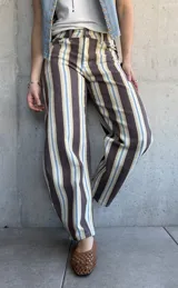 Jean modelo barrel de corte amplio, con diseño de rayas verticales en tonos marrón chocolate, celeste, tostado y blanco.