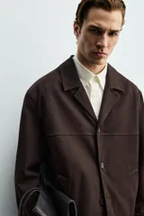 Sobrecamisa de corte regular confeccionada en tejido de mezcla de lyocell y algodón. Presenta cuello con solapas de muesca, cierre frontal con botones, mangas largas con puños abotonados y bolsillos de vivo en la parte frontal.