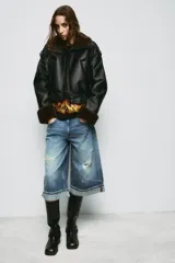 Bermuda de jean estilo jorts de tiro medio, con efecto lavado, cinco bolsillos, detalles de roturas y bajo con vuelta.