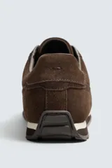 Zapatilla deportiva de estilo casual confeccionada en piel con acabado de serraje. Presenta un diseño de paneles combinados en la parte superior y suela dentada.