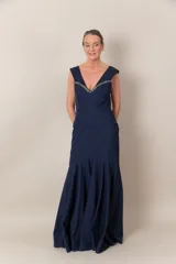 Vestido largo de fiesta azul marino, corte sirena, con escote en V y apliques de piedras bordadas en el escote.