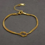 Pulsera de cadena tipo serpiente doble en color dorado, con un diseño de nudo central y cierre de mosquetón con cadena de alargue.