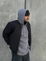 Campera puffer negra de nylon con cierre frontal y cuello alto.