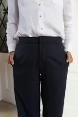 Pantalón de corte sastrero con pierna recta, confeccionado en gabardina con tencel. Presenta un diseño de color azul marino con detalle de rayas laterales en contraste.