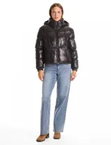 Campera puffer de Michael Kors con acabado brillante, diseño capitoneado, capucha integrada con cordones de ajuste, cuello alto, cierre frontal con tirador metálico y puños elásticos.