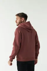 Campera de felpa negra con capucha y cordón ajustable, cierre frontal con cremallera, bolsillos laterales y logo estampado en el pecho.