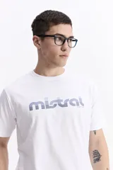 Remera blanca de manga corta con cuello redondo y logo de "Mistral since 1976" estampado en el frente en tonos azules.