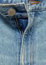 Jeans wide leg de tiro medio, confeccionados en tejido de algodón estilo vaquero, con diseño de cinco bolsillos, cierre de cremallera y botón, y bajo deshilachado.