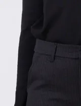 Pantalón de vestir marca Tahari, corte recto y tiro medio, confeccionado en tejido elastizado con diseño de rayas diplomáticas sutiles. Presenta pretina con pasadores, cierre con broche interno y bolsillos funcionales en la parte delantera.