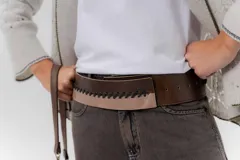 Faja ancha de cuero en tono marrón y tostado, con detalle de costuras decorativas cruzadas en hilo negro en el frente.