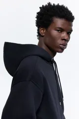 Campera con capucha de felpa color azul marino, con interior cepillado suave. Presenta hombros caídos, cierre frontal, bolsillos canguro delanteros y puños y bajo en punto acanalado. Corte holgado.